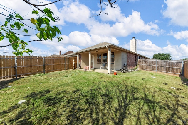 back of house with a yard and a patio area