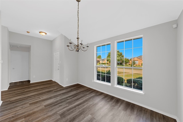 unfurnished dining area with a chandelier and dark wood-type flooring