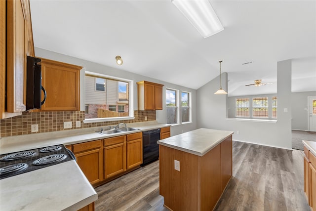 kitchen featuring lofted ceiling, black appliances, a center island, wood-type flooring, and decorative light fixtures