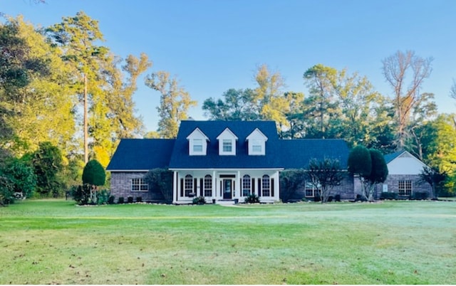 cape cod house featuring a front lawn