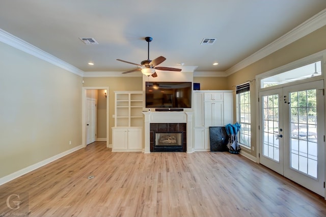 unfurnished living room with crown molding, light hardwood / wood-style flooring, and french doors