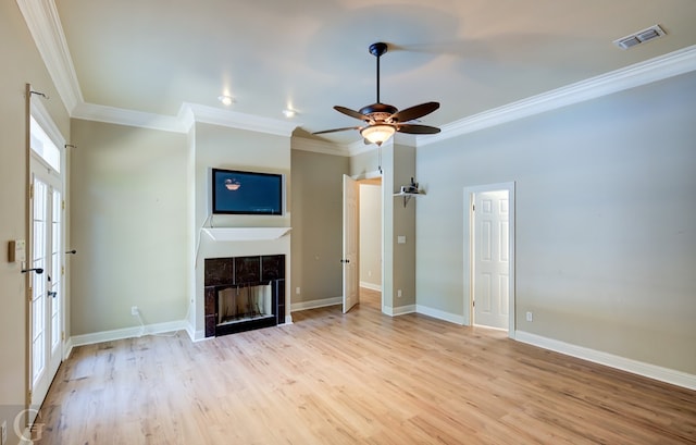 unfurnished living room with ornamental molding, ceiling fan, light hardwood / wood-style floors, and a fireplace