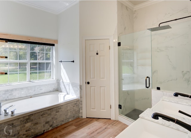 bathroom featuring shower with separate bathtub, ornamental molding, hardwood / wood-style floors, and vanity