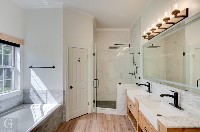 bathroom featuring wood-type flooring, vanity, crown molding, and separate shower and tub