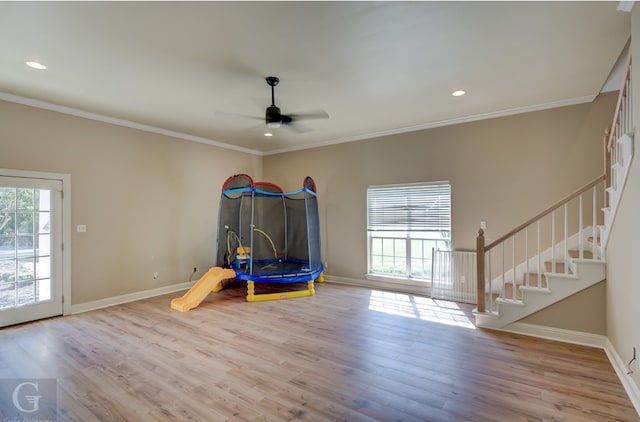 playroom with light hardwood / wood-style flooring, ceiling fan, and ornamental molding