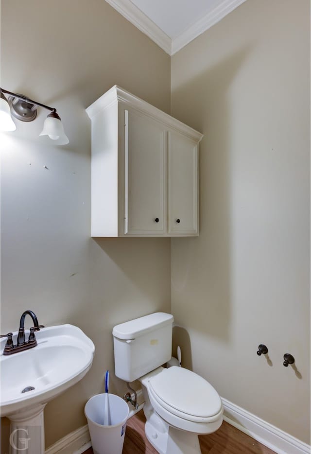 bathroom with wood-type flooring, sink, crown molding, and toilet