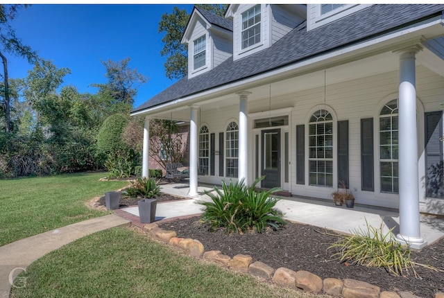 doorway to property featuring a yard and covered porch