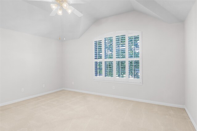 carpeted empty room featuring lofted ceiling, a healthy amount of sunlight, and ceiling fan