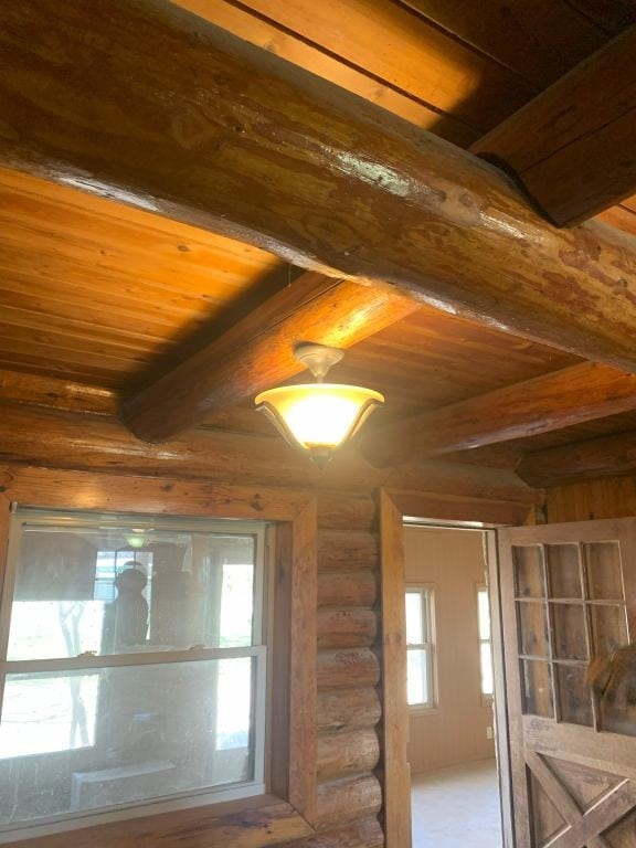 details with wood ceiling, log walls, and beamed ceiling