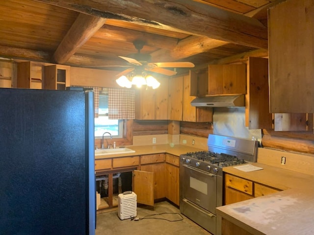 kitchen featuring wood ceiling, stainless steel range with gas cooktop, sink, black refrigerator, and ceiling fan