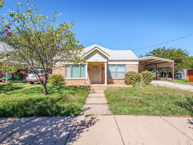 view of front of home with a carport and a front lawn