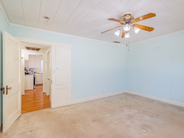 carpeted spare room featuring crown molding and ceiling fan