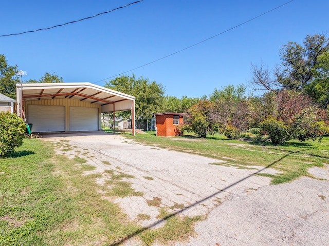 exterior space with a lawn, a carport, an outdoor structure, and a garage