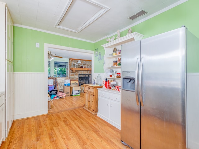 kitchen featuring white cabinets, light wood-type flooring, stainless steel fridge, and crown molding