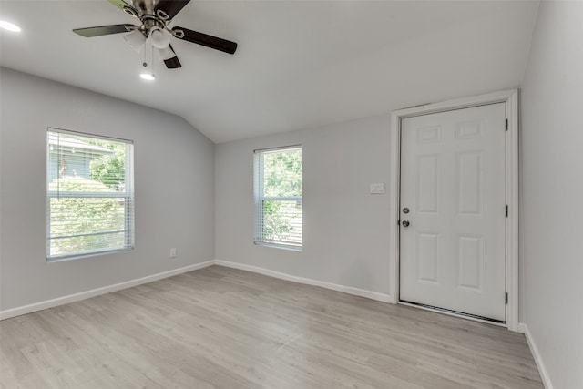 spare room with light hardwood / wood-style flooring, vaulted ceiling, a wealth of natural light, and ceiling fan