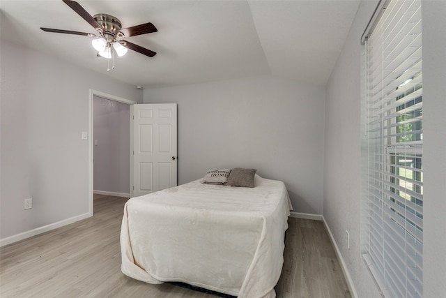 bedroom with light hardwood / wood-style floors, ceiling fan, and lofted ceiling