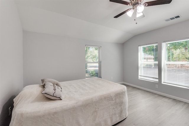 bedroom featuring ceiling fan, lofted ceiling, light wood-type flooring, and multiple windows