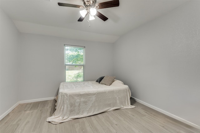 bedroom featuring ceiling fan, light hardwood / wood-style floors, and lofted ceiling