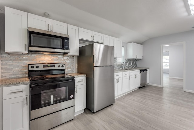 kitchen featuring white cabinets, backsplash, and stainless steel appliances