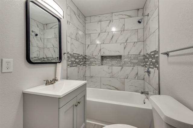 full bathroom with vanity, tiled shower / bath combo, and toilet