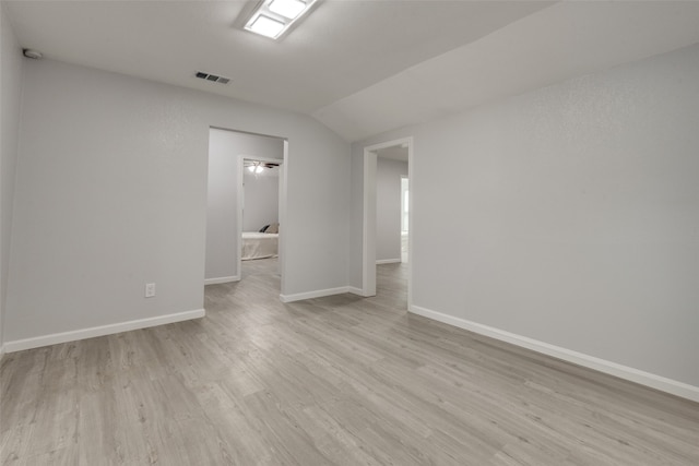 empty room featuring light hardwood / wood-style floors and vaulted ceiling