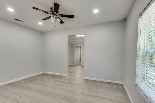 empty room with ceiling fan, light hardwood / wood-style floors, and a wealth of natural light