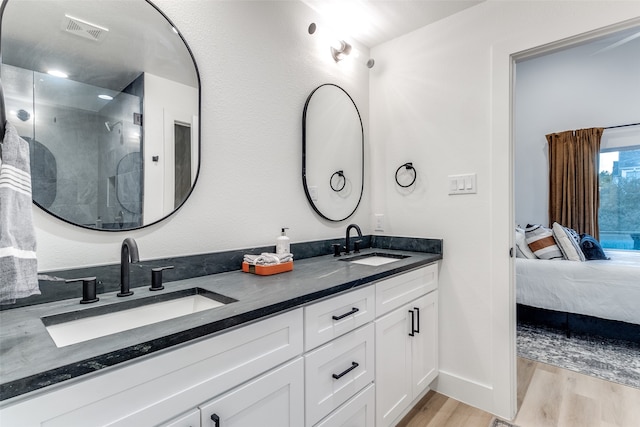 bathroom with walk in shower, vanity, and hardwood / wood-style flooring