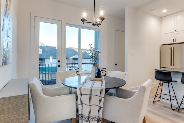 dining room featuring a notable chandelier and light wood-type flooring