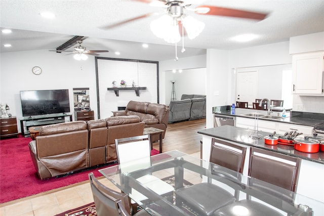 kitchen featuring white cabinets, a textured ceiling, ceiling fan, stainless steel dishwasher, and sink