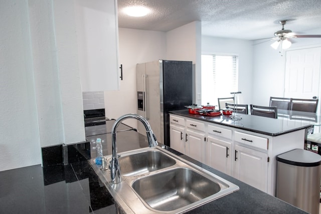 3604 Fort Hunt Dr, Arlington, TX 76016 - kitchen with stainless steel fridge with ice dispenser, a sink, ceiling fan, dark countertops, and a textured ceiling
