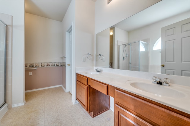 bathroom featuring a shower with door and vanity