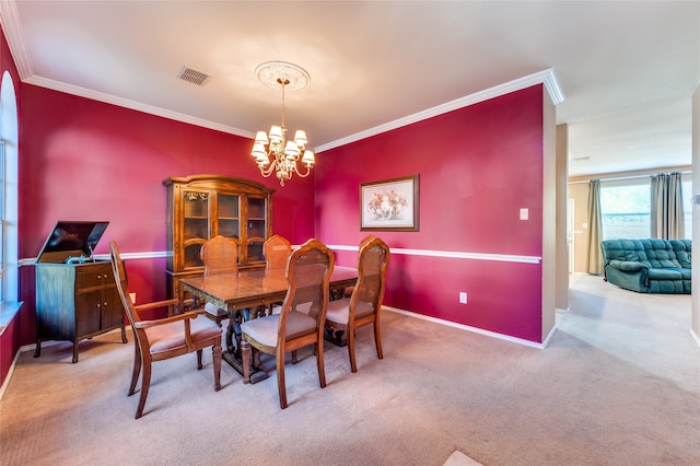 carpeted dining room featuring ornamental molding and a chandelier