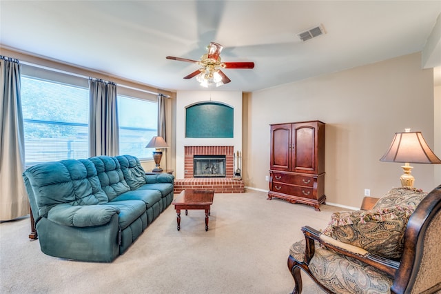 carpeted living room with a brick fireplace and ceiling fan