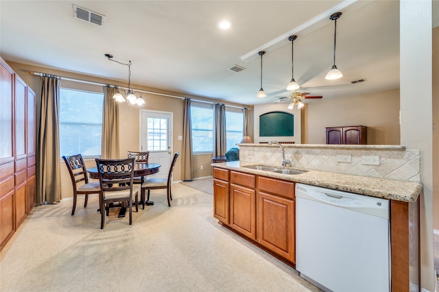 kitchen featuring pendant lighting, light stone counters, sink, ceiling fan with notable chandelier, and white dishwasher