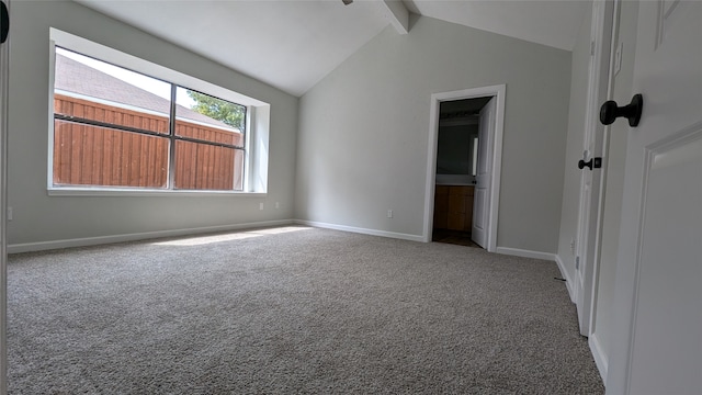 carpeted empty room with vaulted ceiling with beams