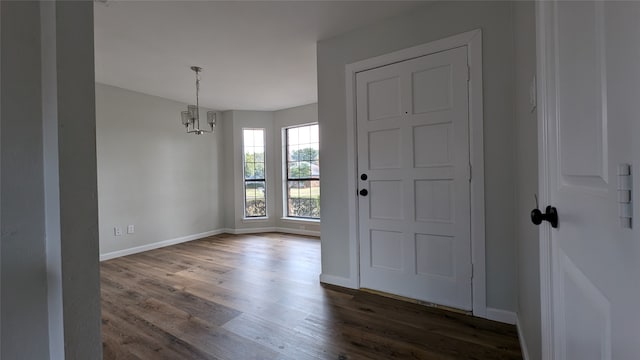 foyer with dark wood-type flooring and a notable chandelier