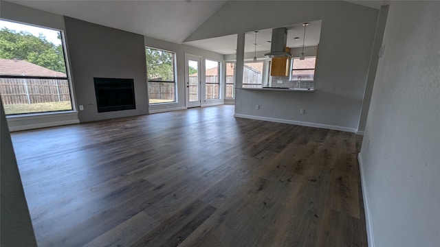 unfurnished living room with sink, dark wood-type flooring, and vaulted ceiling