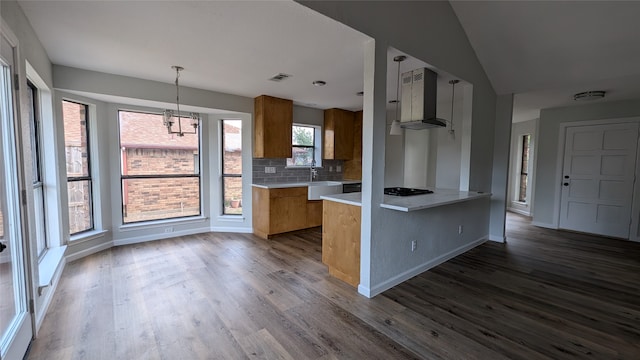 kitchen featuring pendant lighting, backsplash, exhaust hood, dark hardwood / wood-style flooring, and kitchen peninsula