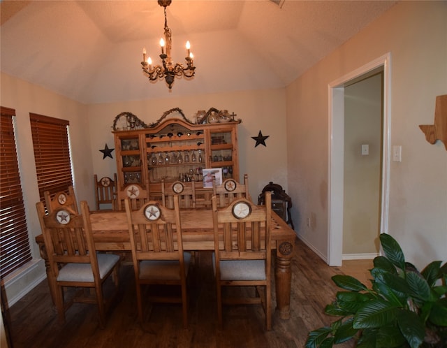 dining space featuring vaulted ceiling, dark hardwood / wood-style flooring, and a chandelier