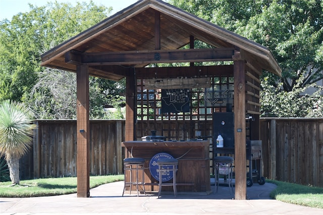 view of community with an outdoor bar, a patio, and a gazebo