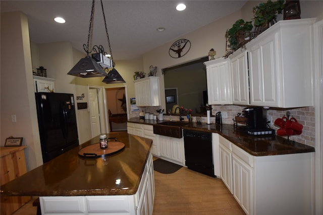 kitchen featuring decorative backsplash, white cabinetry, kitchen peninsula, black appliances, and sink