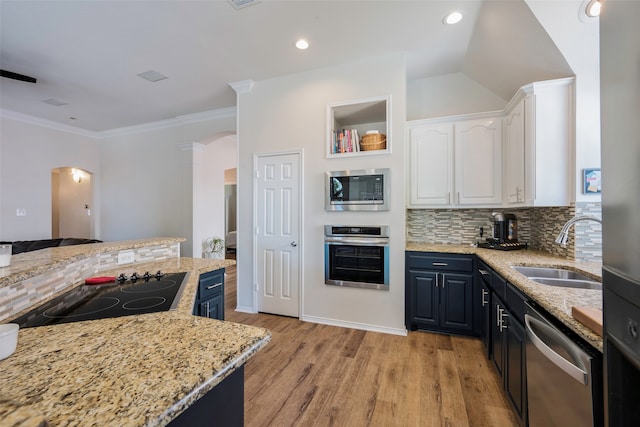 kitchen with light stone countertops, sink, white cabinets, and stainless steel appliances