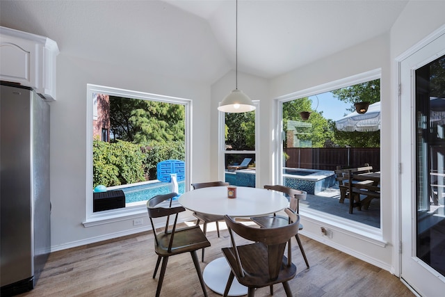 dining area featuring light wood-type flooring and lofted ceiling