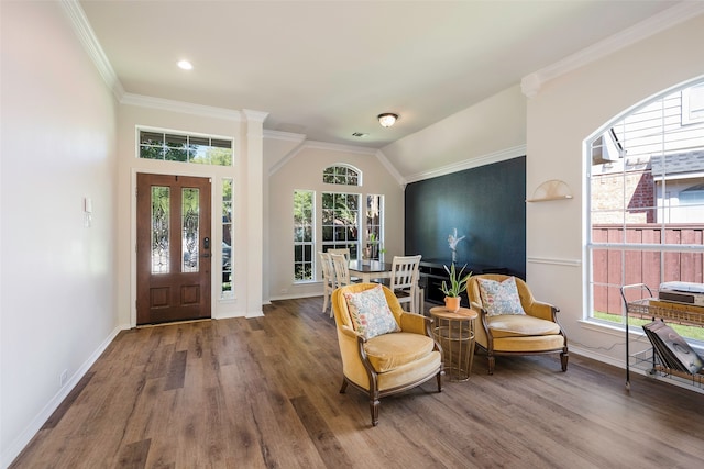 foyer with hardwood / wood-style floors, ornamental molding, a wealth of natural light, and vaulted ceiling