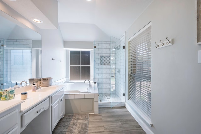 bathroom featuring vanity, vaulted ceiling, and independent shower and bath