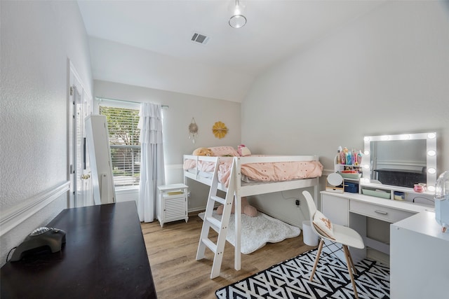 bedroom featuring light hardwood / wood-style floors and vaulted ceiling