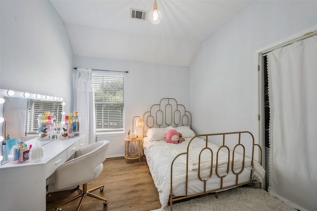 bedroom with light wood-type flooring and vaulted ceiling