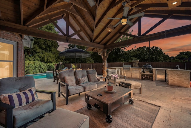 patio terrace at dusk with an outdoor hangout area, area for grilling, a gazebo, a fenced in pool, and a grill