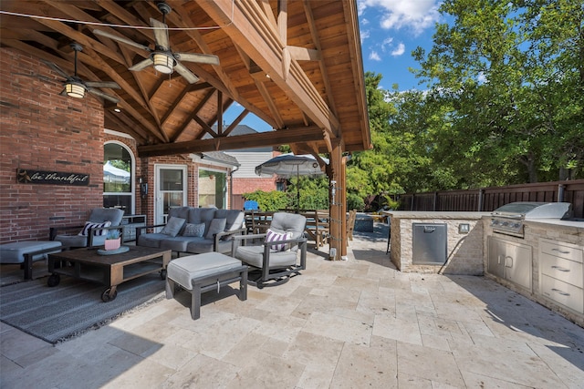 view of patio / terrace with an outdoor living space, an outdoor kitchen, a gazebo, ceiling fan, and area for grilling