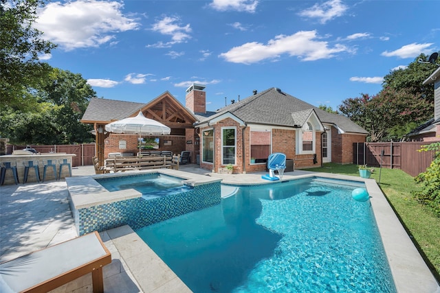 view of swimming pool featuring an outdoor bar, an in ground hot tub, and a patio